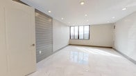 This thoughtfully designed 3-bedroom, 2-bathroom residence offers a clean, contemporary aesthetic across a single floor. The living areas are anchored by striking polished marble-style porcelain tile flooring that reflects light beautifully, creating a bright and airy atmosphere. Recessed lighting throughout enhances the modern feel, while large windows in the main living space frame outdoor views and invite ample natural light.

The kitchen is well-appointed with granite countertops featuring bold veining, gray shaker-style cabinetry, a glass tile backsplash, and stainless steel appliances including a gas range, built-in microwave, and dishwasher. The layout is efficient and functional, making excellent use of available space.

The bedrooms offer a quieter, neutral palette with light wood-toned flooring, recessed lighting, and generous wall space. Each room provides a calm, versatile environment suitable for a variety of uses.

Both bathrooms are finished with elegant marble-look tile work covering the floors and walls, complete with a decorative mosaic border accent. Each bathroom includes a soaking tub, a sleek vanity, and modern fixtures, delivering a polished, spa-like feel. Overall, the unit presents a cohesive, upscale design with quality finishes throughout.