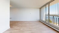 Located at 1 Chapel St in Nanaimo, BC, this well-appointed one-bedroom, one-bathroom unit offers a bright and clean living environment with a thoughtful layout across a single floor. Light-toned hardwood flooring flows seamlessly throughout the main living areas, lending a warm and contemporary feel to the space.

The living room is generously proportioned, featuring large floor-to-ceiling sliding glass doors that open to a balcony, flooding the interior with natural light. The balcony offers breathtaking views of the ocean, with sailboats and lush island scenery visible in the distance — a true standout feature of this unit.

The bedroom is a comfortable and private retreat, benefiting from its own set of large windows that frame the same stunning ocean and harbour views. A built-in sliding door closet provides practical storage while maintaining the room's clean, minimalist aesthetic.

The bathroom is neatly finished with classic white subway tile surrounding a full soaker tub and shower combination. A vanity with a white countertop and tile flooring complete the space with a crisp, functional design.

Throughout the unit, crisp white walls, baseboard heating, and consistent light wood flooring contribute to a cohesive and modern atmosphere. This unit is ideal for those seeking a serene coastal lifestyle in the heart of Nanaimo.