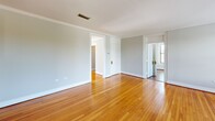 Located at 600 Georgia Ave in Chattanooga, TN, this single-floor 2-bedroom, 2-bathroom residence offers a thoughtfully arranged layout that balances comfort and functionality. Warm-toned hardwood floors flow throughout the main living areas, hallways, and bedrooms, complemented by neutral gray walls and crisp white crown molding that lend a classic, cohesive character to the space.

The living room is generously proportioned, with multiple doorways connecting it to the rest of the home and allowing natural light to filter through. The adjacent dining room features the same rich hardwood flooring and is accented by a chandelier overhead, along with a closet and access to other areas of the home. Two connecting hallways guide you through the residence, with windows fitted with white blinds providing additional natural light.

The kitchen is equipped with rich, dark wood cabinetry, light countertops, a double stainless steel sink, and a stainless steel dishwasher, all set over tile flooring. Both bedrooms offer hardwood floors, crown molding, and windows with outdoor views of surrounding greenery. The spacious primary bedroom features dual windows. The two bathrooms are clean and functional, each with a white vanity, sink, and terrazzo-style tile flooring.