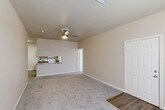 Located at 10888 Buddy Ellis Rd in Denham Springs, Louisiana, this two-story home offers a practical and comfortable layout across two floors. The main level serves as the heart of the home, featuring a spacious living room with plush carpeting and a ceiling fan, which opens to a combined dining area and galley-style kitchen. The kitchen is well-appointed with warm wood cabinetry, granite-style countertops, white appliances including a range, microwave, refrigerator, and dishwasher, all set atop durable wood-look flooring. A dedicated laundry area and a bonus room add versatility to the layout. Carpeted stairs with a warm wood handrail lead to the upper level. The bedroom is a generously sized retreat with soft carpet, a ceiling fan, natural light from a window, and a closet. Two full bathrooms serve the home, each featuring wood cabinetry, granite-style countertops, and tub-shower combinations with wood-look flooring. Neutral beige tones, white trim, and ceiling fans throughout lend the home a clean, consistent aesthetic. Additional closet storage is also available, enhancing the overall functionality of this well-maintained Denham Springs residence.