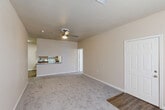 Located at 10888 Buddy Ellis Rd in Denham Springs, Louisiana, this two-story home offers a practical and comfortable layout across two floors. The main level serves as the heart of the home, featuring a spacious living room with plush carpeting and a ceiling fan, which opens to a combined dining area and galley-style kitchen. The kitchen is well-appointed with warm wood cabinetry, granite-style countertops, white appliances including a range, microwave, refrigerator, and dishwasher, all set atop durable wood-look flooring. A dedicated laundry area and a bonus room add versatility to the layout. Carpeted stairs with a warm wood handrail lead to the upper level. The bedroom is a generously sized retreat with soft carpet, a ceiling fan, natural light from a window, and a closet. Two full bathrooms serve the home, each featuring wood cabinetry, granite-style countertops, and tub-shower combinations with wood-look flooring. Neutral beige tones, white trim, and ceiling fans throughout lend the home a clean, consistent aesthetic. Additional closet storage is also available, enhancing the overall functionality of this well-maintained Denham Springs residence.