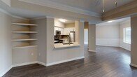 Located in the desirable Buckhead neighborhood of Atlanta, Georgia, this single-floor residence offers a well-appointed layout with thoughtful design details throughout. The open-concept living area features hardwood-style flooring, crown molding, and a tray ceiling, with floor-to-ceiling vertical blinds framing a large window that fills the space with natural light. Built-in shelving adds both character and functionality to the living area, which flows seamlessly into a formal dining space distinguished by elegant wainscoting and crown molding trim.

The kitchen is efficiently designed with white shaker-style cabinetry, light countertops, a grey tile backsplash, and a full suite of stainless steel appliances including a range, over-the-range microwave, and dishwasher. A pass-through window connects the kitchen to the main living area, enhancing the open feel.

Bedrooms feature plush carpeting, crown molding, ceiling fans, and windows that bring in natural light. The bathroom includes wood-look flooring and clean, neutral finishes. A dedicated in-unit laundry area houses a full-size washer and dryer, adding everyday convenience. The overall palette of warm neutrals and crisp white trim creates a clean, inviting ambiance throughout.