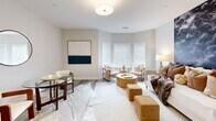 This thoughtfully designed unit at 281 Canal St in Shelton, Connecticut, makes efficient use of its single-floor layout, incorporating a living room, kitchen, and bathroom. The living area is bright and inviting, anchored by a charming bay window that fills the space with natural light. Neutral-toned walls and light hardwood-style flooring run throughout, creating a cohesive and airy aesthetic. The living area offers ample room for both lounging and dining, with a defined dining nook featuring a glass-top table and seating, complemented by a round mirror accent on the wall.

The kitchen is well-appointed with white shaker-style cabinetry extending to the ceiling, stainless steel appliances including a refrigerator, electric range, over-the-range microwave, and dishwasher, plus light countertops that enhance the clean, modern feel. Recessed lighting keeps the space bright and functional.

The bathroom is finished with the same light flooring and neutral walls, featuring a glass-enclosed walk-in shower, brushed nickel fixtures, and clean white fixtures throughout. The overall ambiance of the unit is modern and understated, with consistent finishes that lend a polished, move-in-ready quality.