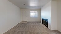 Located in Oro Valley, Arizona, this single-floor residence offers five bedrooms and two bathrooms with a functional, well-organized layout. The living room provides a welcoming focal point with a wood-burning fireplace framed by tile surround and plush carpet underfoot, with natural light filtering in through a front-facing window. It connects openly to the kitchen, which features white shaker cabinetry, light stone-look countertops, wood-look tile flooring, and a full suite of stainless steel appliances including a refrigerator, range, over-the-range microwave, and dishwasher. The spacious primary bedroom is carpeted, includes a ceiling fan, and opens directly to a private balcony with outdoor views. Additional bedrooms are well-sized, with some featuring wood-look flooring and ceiling fans, while others include mirrored sliding closet doors for added storage and visual depth. The bathrooms are clean and bright — one features a tiled walk-in shower with a built-in bench, while the other offers a white vanity with marble-look countertop and wood flooring. A dedicated closet rounds out the storage options. The home's neutral palette and consistent finishes create a cohesive, move-in-ready atmosphere throughout.