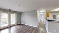 Located at 3825 Hixson Pike in Chattanooga, TN, this single-floor, 3-bedroom, 2-bathroom home offers a well-organized and comfortable layout. Consistent hardwood-style flooring flows throughout, complemented by soft gray walls and crisp white trim, creating a clean and cohesive aesthetic.

The open living area is a standout feature, bathed in natural light through a set of French doors that lead to the exterior. The galley-style kitchen is efficiently designed with light wood cabinetry, dark granite-style countertops, a double-basin stainless steel sink, and white appliances including a range and refrigerator. A breakfast bar provides additional counter space and separation from the living area.

A hallway connects the three bedrooms, each featuring hardwood-style flooring and windows that bring in natural light. The primary bedroom is generously sized with access to a dedicated bathroom equipped with a dual-sink vanity with dark countertops, wood cabinetry, and a tub-shower combination. The second bathroom mirrors the same design finishes. A closet with double doors provides ample storage in the primary suite. The home's straightforward, functional layout makes it an ideal space in the heart of Chattanooga.