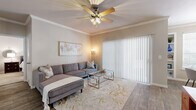 This single-floor residence offers a practical and stylish layout encompassing two bedrooms, two bathrooms, a living room, dining room, kitchen, hallway, entrance, and two closets. The living room is a welcoming centerpiece, featuring crown molding, a ceiling fan with light fixture, wood-look flooring, and a large sliding glass door with vertical blinds that invites natural light. The dining room is distinguished by built-in shelving flanking a bright window and the same warm wood-look flooring carried throughout the main living areas. The kitchen is well-equipped with white cabinetry, granite-style countertops, and a full suite of appliances including a dishwasher, range, and refrigerator. Both bedrooms are carpeted and include ceiling fans; the primary bedroom offers a spacious walk-in closet with wrap-around shelving and hanging rods, along with a large window. The second bedroom also includes an organized walk-in closet. The bathrooms feature wood-look flooring, white vanity cabinetry with granite-style countertops, a large mirror, and a tub-shower combination. Throughout the home, neutral tones and consistent finishes create a cohesive and comfortable living environment.