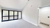 Located at 839 Sheridan Ave. in the sought-after community of Bexley, Ohio, this well-appointed one-bedroom, one-bathroom residence offers a thoughtfully designed single-floor layout. The open-concept kitchen and living area serves as the heart of the home, where the kitchen stands out with stainless steel appliances—including a refrigerator, range, microwave, and dishwasher—complemented by granite countertops, white shaker cabinetry, and light hardwood flooring. A stylish pendant light fixture adds a modern touch above the workspace. The living area impresses with soaring vaulted ceilings that create a dramatic sense of openness, soft carpeting underfoot, and large floor-to-ceiling windows paired with a sliding glass door that opens to a private balcony overlooking lush greenery. The spacious primary bedroom is carpeted and filled with natural light from a wide window. The full bathroom features a white vanity with a dark countertop, a tub/shower combination, light wood-look flooring, and black accent hardware for a contemporary finish. A dedicated closet and hallway complete the efficient floor plan. The neutral, light gray color palette throughout contributes to a clean, modern, and welcoming ambiance.