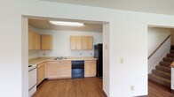 This two-floor residence offers a practical and well-organized layout designed for comfortable everyday living. The kitchen is equipped with light maple cabinetry providing ample upper and lower storage, light-toned countertops, a double sink, an electric range, a dishwasher, and a refrigerator. Wood-look flooring runs throughout the kitchen, creating a clean transition from the adjacent living area. The spacious living room features wall-to-wall carpeting, a textured ceiling, and a window that allows natural light to fill the room. The open sightline between the living area and kitchen enhances the sense of space throughout the main level. The bedrooms are carpeted and well-lit, each featuring baseboard heating and windows fitted with blinds that bring in natural light and outdoor views. Two bathrooms serve the residence — one with a tub and shower combination, vanity, and wood-look flooring, and a second half bath with a vanity and mirror. A dedicated laundry room with overhead shelving and wood-look flooring adds everyday convenience. Throughout the space, neutral wall tones and consistent flooring materials create a cohesive and functional living environment across both floors.
