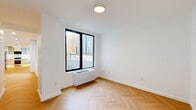 Located at 163 Willoughby Street in the heart of Downtown Brooklyn, this thoughtfully designed 2-bedroom, 1-bathroom residence offers a clean, modern aesthetic throughout. Herringbone-patterned hardwood floors flow seamlessly across the entire unit, lending warmth and visual interest to each room.

The kitchen is outfitted with floor-to-ceiling white cabinetry featuring black hardware accents, a stainless steel range, built-in microwave, and a deep undermount sink with a matte black faucet. Under-cabinet lighting adds a refined finishing touch, and a window provides natural light to the space.

Both bedrooms are bright and airy, featuring large black-framed windows that frame views of the surrounding Brooklyn skyline and greenery. The primary bedroom is generously proportioned and includes a double-door closet, while the second bedroom also benefits from oversized windows and ample natural light.

The bathroom showcases a distinctive design with vertically laid tile walls in warm earth tones, terrazzo-style flooring, a wood-framed vanity with open shelving, recessed accent lighting, and a pendant light — creating a spa-like atmosphere. A glass-enclosed soaking tub completes the space.

Throughout the unit, white walls, black hardware details, and clean lines create a cohesive, contemporary living environment.
