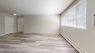 This 2-bedroom, 1-bathroom unit at 2008 Brewster Street in Saint Paul, Minnesota offers a practical and well-organized single-floor layout. The living room features light gray laminate flooring, a textured ceiling, large windows that let in natural light, and a wall-mounted air conditioning unit alongside baseboard heating. The adjacent kitchen is equipped with white cabinetry, a white electric range, a full-size refrigerator, and a tile floor, providing a clean and functional cooking space with a window for added brightness. Both bedrooms are finished with plush carpet and ceiling fans with light fixtures. The primary bedroom offers generous proportions with a louvered double closet and direct access to the hallway leading to the bathroom. The second bedroom mirrors this layout with its own ceiling fan, closet, and a window with natural light. The full bathroom is finished with classic white tile on the floors and tub surround, featuring a tub-shower combination. A dedicated hallway connects the rooms efficiently, and a closet provides additional storage. Baseboard heating is present throughout the unit, ensuring consistent warmth year-round.