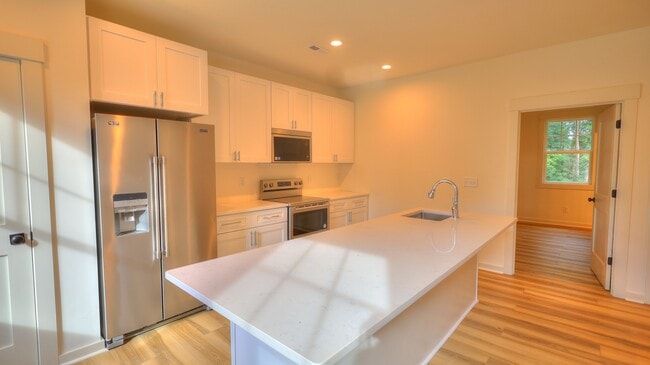 Chef's kitchen with eat in island, quartz countertops and stainless appliances. - 345 W Stewart Ave