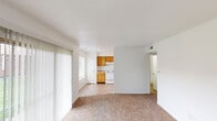 Located at 2518 Tamarack Ln in Indianapolis, Indiana, this single-floor residence offers a practical and comfortable layout designed for everyday living. The open living area is finished with wall-to-wall carpet and features large sliding glass doors dressed with vertical blinds, allowing generous natural light to pour in while providing direct access to the outdoors. An additional window in the living space further brightens the interior. The kitchen flows naturally from the living area and is outfitted with warm honey-toned wood cabinetry offering ample storage, light-colored countertops, a double stainless steel sink, a white electric range with a range hood, and a refrigerator, all set on easy-care tile flooring. The bedrooms are carpeted and bathed in natural light through windows that overlook the surrounding neighborhood, providing a clean and restful atmosphere. The bathroom includes a full tub and shower combination with white surround walls and built-in corner shelving, complemented by chrome fixtures. Throughout the home, crisp white walls and clean lines create a bright, neutral backdrop that is easy to personalize. The single-story layout ensures seamless, step-free movement throughout the entire residence.
