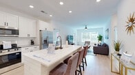 This contemporary 1020 square foot apartment in Wilmington, NC offers a harmonious blend of style and functionality. The open-concept floor plan seamlessly integrates the living room and kitchen, creating a spacious feel. The living area is bathed in natural light from large windows and features a ceiling fan, comfortable seating, and tasteful decor.

The kitchen boasts pristine white cabinetry, stainless steel appliances, and a convenient island, perfect for meal preparation or casual dining. Light wood-look flooring flows throughout, adding warmth to the crisp white walls.

Two bedrooms, including a 170 square foot primary suite, provide ample space for rest and relaxation. The bathrooms are modern and well-appointed, with one featuring a double vanity and a combination shower/tub.

Storage is plentiful with multiple closets, including a walk-in closet with built-in shelving. The apartment also includes a dedicated workspace with natural light, ideal for a home office or study area.

Additional amenities include recessed lighting, stylish fixtures, and window treatments for privacy. The overall design emphasizes clean lines and a neutral color palette, creating a calm and inviting atmosphere throughout the space.
