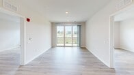 Located at 3535 Grandview Dr in Macungie, PA, this well-appointed 2-bedroom, 2-bathroom residence offers a thoughtfully designed single-floor layout with modern finishes throughout. Light-toned hardwood-style flooring flows seamlessly across the living spaces, complementing the clean, neutral color palette that gives the home a bright and airy feel.

The open-concept kitchen is a standout feature, showcasing gray shaker-style cabinetry, white quartz countertops, a classic subway tile backsplash, and stainless steel appliances including a range, over-the-range microwave, and refrigerator. A peninsula with pendant lighting adds both function and style, connecting the kitchen to the living area.

The living room is generously sized and bathed in natural light, with sliding glass doors opening to a private balcony that overlooks lush greenery and a scenic pond with open skies beyond — an ideal setting for relaxing or entertaining.

The primary bedroom is spacious and well-proportioned, featuring a stylish barn door that leads to the en-suite bathroom and a walk-in closet outfitted with built-in shelving and dual hanging rods. The bathrooms are finished with clean white tile, including a full soaking tub with tiled surround. A dedicated utility room and additional closet provide practical storage throughout.