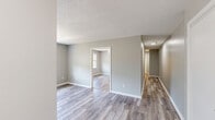 Located at 1379 Foxon in North Branford, CT, this single-floor, one-bedroom, one-bathroom unit offers a well-organized and efficiently designed layout. Light-toned hardwood-style flooring runs throughout the space, complemented by neutral gray walls and white trim, creating a clean and cohesive aesthetic. Textured ceilings add a classic architectural detail found across the living areas and bedroom.

The living area flows openly into the hallway corridor, which connects the main spaces with ease. The kitchen is a functional standout, featuring warm oak cabinetry that wraps in an L-shaped configuration, providing generous storage and counter space. White appliances — including a refrigerator, dishwasher, and range with an overhead microwave — complete the setup.

The bedroom is a comfortable, well-proportioned retreat benefiting from natural light through a large window with outdoor views of the surrounding neighborhood. Notably, it includes two closets, offering excellent storage capacity. Additional closets throughout the unit, along with a dedicated utility room, further enhance storage options.

The bathroom is clean and straightforward, featuring a full tub and shower combination with chrome fixtures. Overall, this unit presents a tidy, move-in-ready interior with practical amenities suited for comfortable everyday living.