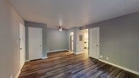 Located at 3305 Silverthorn Ln in Louisville, Kentucky, this single-floor residence offers a well-appointed layout with a clean, modern aesthetic throughout. The main living area is finished with rich, dark hardwood-style flooring and painted in a contemporary cool gray palette, creating a calm and cohesive atmosphere. A ceiling fan provides added comfort, and the open sightlines to the kitchen make the space feel connected and functional. Sliding glass doors lead to a private balcony, bringing in generous natural light and offering pleasant views of the surrounding greenery. The kitchen is equipped with stainless steel appliances — including a refrigerator, electric range, over-the-range microwave, and dishwasher — complemented by crisp white cabinetry, light countertops, and a tile backsplash. The bedroom features plush carpeting, soft natural light from a window overlooking mature trees, and ample wall space. The bathroom is a standout, showcasing a tub and shower combination finished with elegant marble-style tile surrounds and brushed gold fixtures, paired with hardwood-style flooring for a refined touch. Overall, this residence combines practical updates with stylish finishes for comfortable everyday living.