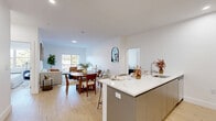 Located at 475 Main Street in Orange, NJ, this well-appointed 2-bedroom, 2-bathroom residence offers a thoughtfully designed open-concept layout with modern finishes throughout. Light hardwood flooring flows seamlessly across the entire space, complementing the bright, white walls that reflect abundant natural light.

The combined kitchen and living area serves as the heart of the home. The contemporary kitchen features a large waterfall-edge quartz island with seating for multiple guests, sleek two-tone cabinetry, a white subway tile backsplash, and stainless steel appliances including a refrigerator, range, and microwave. The living area extends naturally from the kitchen and opens directly onto a private balcony with outdoor views of surrounding greenery.

The spacious primary bedroom is filled with natural light from large windows and offers generous closet space. The second bedroom is equally bright and well-proportioned. Both bathrooms are finished in a clean, modern aesthetic, featuring floating wood-toned vanities, round backlit mirrors, and neutral tile work. One bathroom includes a soaking tub with a glass shower partition, while the second features a sleek, minimalist design.

Additional conveniences include dedicated in-unit laundry and ample closet storage, making this a complete and functional home.