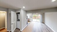 This thoughtfully renovated two-floor home showcases a clean, modern aesthetic throughout, with neutral gray walls, bright white trim, and recessed lighting that create a fresh and welcoming atmosphere. The main level centers around an open living and dining area finished with durable wood-look flooring, recessed lighting, and a ceiling fan, flowing seamlessly toward a sliding glass door that opens to a private, fenced backyard. The fully updated kitchen is a standout feature, outfitted with crisp white shaker cabinetry, light quartz countertops, stainless steel appliances including a range, microwave, dishwasher, and refrigerator, and a window that brings in natural light. Nearby, a dedicated in-unit laundry closet houses a stacked washer and dryer for added convenience. A half bath on the main level provides practical functionality for guests. Upstairs, generously sized bedrooms are carpeted for comfort and equipped with ceiling fans and ample natural light through large windows. A full bathroom on the upper level features a tub-shower combination with sliding glass doors, modern vanity with marble-style countertop, and wood-look tile flooring. The home's cohesive finishes and thoughtful layout make it a move-in ready space designed for everyday living.
