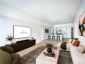 Open living area with clean-lined finishes, a generous lounge space, and a kitchen with bar seating designed for gathering and everyday comfort. - Modera Bridle Trails