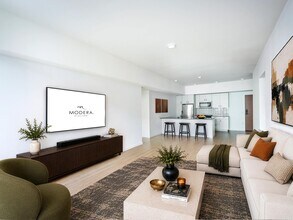 Open living area with clean-lined finishes, a generous lounge space, and a kitchen with bar seating designed for gathering and everyday comfort. - Modera Bridle Trails