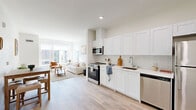 Located at 1720 Research Park Dr in Davis, CA, this modern 1-bedroom, 1-bathroom unit offers a thoughtfully designed open-concept layout finished with light hardwood flooring throughout. The kitchen is a standout feature, showcasing crisp white shaker cabinetry extending to the ceiling, a white subway tile backsplash, light quartz countertops, and a full suite of stainless steel appliances including a range, microwave, dishwasher, and refrigerator. The kitchen flows seamlessly into the living area, which is bathed in natural light from oversized windows offering views of the surrounding neighborhood. A welcoming entryway with recessed lighting and a closet provides a clean transition into the living space. The bedroom is a comfortable retreat featuring a window with outdoor views, and ample room for furnishings. The bathroom is finished with white cabinetry, a dark countertop vanity, and a full shower-tub combination. Clean white walls, consistent flooring, and modern fixtures give the entire unit a cohesive, contemporary aesthetic well-suited for comfortable urban living in Davis.