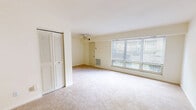 Located at 940 Chumley Rd in Portsmouth, Virginia, this 2-bedroom, 1-bathroom home offers a practical and comfortable single-floor layout. The living area is bright and open, featuring plush wall-to-wall carpeting, a ceiling fan, and a wide bank of windows fitted with blinds that invite generous natural light and outdoor views. The space is clean and neutral throughout, with cream-toned walls that lend a warm, airy feel.

The kitchen is efficiently designed with light wood cabinetry, dark laminate countertops, white appliances including an electric range and refrigerator, and tile flooring. A pantry provides additional storage, complementing the kitchen's functionality. The adjacent dining room connects the kitchen and living areas seamlessly.

Both bedrooms are carpeted and well-proportioned, with the primary bedroom offering a notably spacious footprint, a large bi-fold closet, and a wide window that fills the room with natural light. The second bedroom also features a closet and window with outdoor views. A hallway connects the bedrooms to the full bathroom, which includes a tiled tub-shower combo with a grab bar, tile wainscoting, and tile flooring. The overall layout is straightforward and functional, making excellent use of the available floor space.