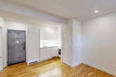 Located at 5530 Ch De La Côte-Saint-Luc in Montréal, this efficiently planned unit makes excellent use of its footprint across a single floor. The main living area is bright and clean, finished with warm honey-toned hardwood flooring and crisp white walls that reflect natural light from a window overlooking greenery outside. Recessed ceiling lighting adds a modern touch throughout.

The kitchenette is neatly integrated into the living space, featuring sleek, handle-free white cabinetry, a countertop with sink, and a built-in oven — offering a streamlined and functional cooking area. A louvred door provides access to additional utility space.

The bathroom is a standout feature, finished to a high standard with large-format light grey tiles on both the floor and walls. It includes a glass-enclosed walk-in shower with full grey tile surround, a rainfall showerhead, a wall-mounted vanity with sink, and a toilet — all finished in a cohesive, contemporary palette. Recessed lighting and clean lines give the bathroom a polished, spa-like feel.

A hallway connects the spaces efficiently, and a dedicated closet provides practical storage. The overall design is minimal and modern, with a neutral colour scheme that creates a calm and functional living environment.
