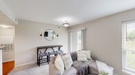 Located at 3340 Hampton Point Drive in Silver Spring, MD, this efficiently designed one-bedroom, one-bathroom unit offers a comfortable and well-appointed single-floor layout. The living room serves as the heart of the home, featuring a classic fireplace with a white mantle, neutral carpet flooring, and large windows that invite abundant natural light. A glass door provides direct outdoor access, enhancing the airy feel of the space. The kitchen is equipped with warm honey-toned wood cabinetry extending to the ceiling, granite-style countertops, a stainless steel sink, and white appliances including a refrigerator, electric range, and over-the-range microwave. Hardwood-style flooring adds warmth to the kitchen area. The bedroom is a tranquil retreat with soft carpet, a ceiling fan, a spacious closet, and a large window overlooking a green outdoor view. Neutral, warm-toned walls throughout create a cohesive and calming ambiance. The bathroom mirrors the kitchen's design aesthetic, featuring matching wood cabinetry, granite-style countertops, hardwood-style flooring, and a full shower-tub combination. The overall layout is thoughtfully organized to maximize functionality within a compact and inviting footprint.