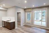 Located at 11450 80 Ave NW in Edmonton, Alberta, this thoughtfully designed 2-bedroom, 2-bathroom unit offers modern living across a single floor. The open-concept layout seamlessly connects the kitchen and living area, both finished with light-toned laminate hardwood flooring and recessed pot lighting throughout. Large windows and a glass-panelled entry door flood the living space with natural light and provide views of the surrounding neighbourhood.

The contemporary kitchen is outfitted with stainless steel appliances including a French door refrigerator, electric range, and built-in microwave, complemented by a combination of rich dark wood and crisp white upper cabinetry, and clean white quartz countertops. A dedicated laundry area houses a stacked Samsung washer and dryer for added convenience.

The spacious primary bedroom features a large window overlooking the exterior, filling the room with natural light. Both bathrooms are finished to a high standard, with marble-look porcelain tile flooring, dark wood vanities, white quartz countertops, and LED-backlit mirrors. One bathroom includes a soaker tub and shower combo, while the other offers a walk-in shower. Two closets and a connecting hallway complete the functional and well-appointed layout.