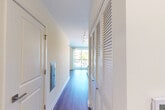 Located at 122 E Northwest Hwy in Mount Prospect, Illinois, this one-bedroom, one-bathroom residence offers a clean, modern aesthetic throughout its single-floor layout. The entrance opens into a bright hallway finished with hardwood-style flooring and track lighting overhead, flanked by louvered closet doors that provide ample storage. Natural light filters through at the end of the corridor, drawing the eye toward the open living area beyond.

The combined dining and living room is an airy, open space with neutral walls and large windows dressed with blinds, allowing for abundant natural light. The kitchen is a standout feature, boasting a galley-style design with light wood cabinetry, white upper cabinets, white quartz countertops, a subway tile backsplash, a stainless steel sink, and a full suite of stainless steel appliances including a gas range, microwave, and refrigerator.

The bedroom is a calm, neutral retreat with hardwood-style flooring, a window with blinds, and a built-in closet with paneled doors. A second closet space features a sleek black sliding barn door. The bathroom is clean and functional, finished with wood-look flooring, a white vanity, and modern fixtures. A dedicated laundry area and utility room add further practicality to this efficiently designed home.