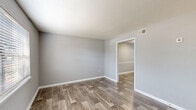 Located at 202 Saint James Ave in Goose Creek, SC, this two-story home offers 2 bedrooms and 2 bathrooms spread evenly across both floors. The interior is finished with a consistent neutral gray color palette and white trim, creating a clean, modern aesthetic throughout.

The main floor houses the living room and kitchen. The living room features wood-look plank flooring, a textured ceiling, and a window with blinds that invites natural light. The kitchen is well-equipped with white cabinetry, light countertops, a double-basin stainless steel sink, and a full suite of black appliances including a gas range, over-the-range microwave, refrigerator, and dishwasher. An adjacent dining area provides additional functional space.

Upstairs, both bedrooms are carpeted and generously sized, with the primary bedroom offering a comfortable layout and dedicated closet access. Each bathroom features wood-look flooring, a vanity with a light countertop, a toilet, and gold-tone hardware accents. One bathroom includes a window for natural light and a tub/shower combination.

A staircase connects both levels, and a hallway and closet provide added storage and circulation. The home's cohesive finishes and practical layout make it a well-organized and functional living space.