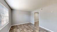 Located at 202 Saint James Ave in Goose Creek, SC, this two-story home offers 2 bedrooms and 2 bathrooms spread evenly across both floors. The interior is finished with a consistent neutral gray color palette and white trim, creating a clean, modern aesthetic throughout.

The main floor houses the living room and kitchen. The living room features wood-look plank flooring, a textured ceiling, and a window with blinds that invites natural light. The kitchen is well-equipped with white cabinetry, light countertops, a double-basin stainless steel sink, and a full suite of black appliances including a gas range, over-the-range microwave, refrigerator, and dishwasher. An adjacent dining area provides additional functional space.

Upstairs, both bedrooms are carpeted and generously sized, with the primary bedroom offering a comfortable layout and dedicated closet access. Each bathroom features wood-look flooring, a vanity with a light countertop, a toilet, and gold-tone hardware accents. One bathroom includes a window for natural light and a tub/shower combination.

A staircase connects both levels, and a hallway and closet provide added storage and circulation. The home's cohesive finishes and practical layout make it a well-organized and functional living space.