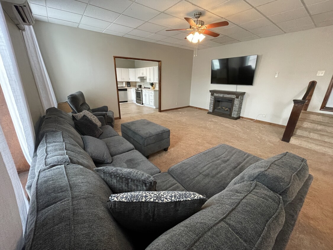Large living room with electric fireplace and 75" Smart Tv - 259 S Miami St