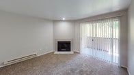 This single-floor residence at 62nd Way S in Kent, Washington, offers a practical and well-appointed layout spread across a thoughtfully organized floor plan. The entry foyer welcomes visitors with tile flooring that transitions into plush carpeting extending throughout the living areas and bedrooms, creating a warm and cohesive feel.

The living room serves as a central gathering space, highlighted by a tile-surround fireplace and a sliding glass door framed by vertical blinds, allowing natural light to filter in while providing access to the outdoors. The kitchen is efficiently designed with dark cabinetry, light countertops, tile flooring, and stainless steel appliances including a range, dishwasher, and refrigerator. Louvered bi-fold doors conceal additional pantry or storage space, and a window above the sink brings in natural light.

The bedrooms are carpeted and feature windows with blinds that offer views of the surrounding greenery, along with baseboard heating for year-round comfort. The bathroom includes a vanity with dark cabinetry, a single sink with countertop space, and a separate water closet with a tiled tub-shower combination. A walk-in closet adjacent to the bathroom provides generous storage. Overall, the space presents a clean, functional design suited for comfortable everyday living.