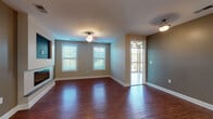 Located at 22 Odara Dr in Forest, Virginia, this single-floor home offers a well-designed layout with a cohesive blend of practical and refined finishes throughout. The open living area is anchored by rich hardwood flooring that extends across the main living space, a sleek linear fireplace, and multiple windows fitted with blinds that allow for ample natural light. The kitchen is a standout feature, equipped with dark espresso-stained cabinetry, granite countertops, stainless steel appliances including a refrigerator, range, and microwave, as well as a double-basin sink set into a generous island with pendant lighting overhead. Light wood flooring in the kitchen complements the darker cabinetry for a balanced aesthetic. The bathroom features dark wood vanity cabinetry with granite countertops, tile flooring, and a walk-in shower with clean white surround. An additional bathroom includes matching cabinetry and a toilet alcove with grab bars. The bedrooms are carpeted for comfort and are served by spacious walk-in closets with wire shelving systems providing ample storage. Neutral wall tones throughout the home create a versatile backdrop, and the overall layout is functional and well-proportioned for everyday living.