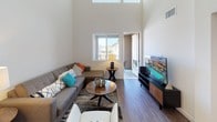 Located at 426 W Washington Ave in Escondido, CA, this modern two-story residence offers a clean, contemporary design with a bright, open layout throughout both levels. The living room is a standout space, featuring soaring double-height ceilings, large windows that flood the room with natural light, and direct access to an outdoor balcony. Wood-look flooring runs seamlessly through the main living areas, lending warmth and cohesion to the design.

The kitchen is well-appointed with sleek grey cabinetry, white quartz countertops, stainless steel appliances including a gas range, microwave, and side-by-side refrigerator, and a sophisticated grey tile backsplash. An adjacent dining area provides a comfortable space for everyday meals.

The bedrooms are carpeted for comfort, each offering a calm, neutral palette. One bedroom features a ceiling fan and direct access to a full bathroom with a shower-tub combo. Another bedroom connects to a dual-sink ensuite bath finished in crisp white with wood-look flooring. A spacious walk-in closet with built-in shelving and hanging rods offers generous storage. The upper level includes an open loft-style area with recessed lighting and windows. Additional full bathroom with tub-shower serves the remaining spaces, completing this well-designed home.