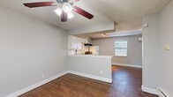 Located at 3201 Laura Koppe Rd in Houston, TX, this single-floor, one-bedroom, one-bathroom unit offers a practical and efficient layout. Rich wood-look flooring flows throughout the space, complementing the neutral gray walls and crisp white trim for a clean, cohesive aesthetic.

The open-concept kitchen and living area form the heart of the unit. The kitchen features white cabinetry, a subway tile backsplash, light granite-style countertops, a peninsula breakfast bar, and white appliances including a refrigerator and range. A track lighting fixture illuminates the kitchen, while a ceiling fan with a light kit serves the adjoining living area. A wall-mounted mini-split HVAC unit provides efficient climate control, and a window allows natural light into the shared space.

The bedroom is a comfortable, well-proportioned room with its own ceiling fan, a large window with blinds, and a dedicated closet for storage. Multiple windows throughout the unit ensure consistent natural light.

The full bathroom is finished with large-format tile in the shower/tub surround, tile flooring, a white vanity with sink, and a window that adds ventilation and light. The textured ceilings are consistent throughout, adding a classic residential character to this straightforward and functional Houston home.