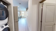 Located at Centennial Park Blvd in Alcoa, Tennessee, this one-bedroom, one-bathroom unit offers a well-designed layout with modern finishes throughout. A central hallway connects the main living areas, providing a clean and organized flow through the space. The kitchen is a standout feature, showcasing rich dark cabinetry that extends floor to ceiling, light stone countertops, a classic white subway tile backsplash, and a full suite of stainless steel appliances including a range, microwave, and dishwasher. A window above the sink brings in natural light, enhancing the kitchen's open feel. Light wood-style flooring runs through the main living and kitchen areas, adding warmth and continuity. The bedroom offers plush carpeting underfoot, a ceiling fan, and generous storage with two built-in closets — one standard and one with additional shelving. The bathroom is finished with elegant marble-look tile flooring, a dark vanity with a stone countertop, and a full tub-shower combination with tiled surround and recessed shelving. Recessed lighting throughout the unit adds a polished, contemporary touch, while the overall neutral color palette creates a bright and welcoming ambiance.