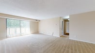 Located at 20360 Parkview Ave in Rocky River, Ohio, this single-floor residence offers a well-organized layout designed for comfortable everyday living. The expansive main living area is finished with plush wall-to-wall carpeting and neutral beige tones throughout, creating a bright and inviting atmosphere. Large vertical-blind-covered sliding doors allow generous natural light to fill the space, enhancing its open, airy feel. A second living or dining area connects seamlessly to the kitchen, providing a practical flow between entertaining and meal preparation.

The kitchen is outfitted with warm oak cabinetry offering ample storage, light countertops, and tile flooring. White appliances including a range, microwave, dishwasher, and refrigerator are included. A peninsula countertop adds additional workspace and reinforces the kitchen's functional design.

The bedrooms are carpeted and receive natural light through window blinds, offering a comfortable, private retreat. The primary bedroom features a walk-in closet and direct access to an en-suite bathroom equipped with an extended vanity, oak cabinetry, and a glass-enclosed tile shower. A secondary full bathroom mirrors the same design aesthetic, featuring a single-sink oak vanity, tile flooring, and a large mirror. The overall ambiance is clean, neutral, and move-in ready.