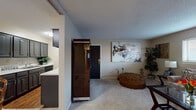 Located at 202 N Rock Rd in Wichita, Kansas, this single-floor residence offers a well-organized and functional layout across multiple living spaces. The entryway opens directly into a generously sized living room, finished with plush carpeting and a textured ceiling. Wide horizontal windows allow natural light to fill the room, creating a bright and welcoming atmosphere. The living area provides ample space for comfortable seating arrangements and decorative accents.

Adjacent to the living room is a dedicated dining area, carpeted and framed by neutral walls, offering an intimate setting for meals. The kitchen features dark cabinetry with raised panel detailing, light countertops, a stainless steel sink, and hardwood-style flooring, combining practicality with a clean aesthetic.

The primary bedroom is a quiet retreat with carpeted floors, neutral walls, a window with blinds, and dark wood furnishings. A second bedroom, also carpeted and naturally lit, provides flexible space suitable for various uses. The bathroom is finished with dark cabinetry, a marble-style countertop, hardwood-style flooring, and a decorative framed mirror, offering a polished and functional design. Throughout the home, consistent finishes and textured ceilings contribute to a cohesive and comfortable living environment.