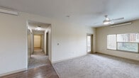 Located at 301 SE 166th Ave in Vancouver, WA, this single-floor unit offers a practical and comfortable layout with three bedrooms, three bathrooms, a combined kitchen and living room, a hallway, and a closet. The kitchen is well-appointed with warm wood-tone cabinetry, dark countertops, wood-look vinyl flooring, and black appliances including a refrigerator, range, and dishwasher — providing ample storage and workspace. The living area flows naturally from the kitchen, creating an open, connected common space. Each of the three bedrooms features neutral carpet flooring and warm beige walls, contributing to a calm and understated atmosphere. The primary bedroom includes a ceiling fan, a wall-mounted HVAC unit, and a window that allows natural light and outdoor views. The bathrooms are finished with wood-look flooring, light wood vanities with dark countertops, and clean, functional fixtures — one bathroom includes a full bathtub and grab bars. Throughout the unit, the consistent use of neutral tones, clean lines, and practical finishes creates a cohesive and livable environment well-suited for everyday comfort.