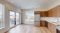 Located in Philadelphia's vibrant Northern Liberties neighborhood, this modern 2-bedroom, 2-bathroom unit at 130 W Girard Ave offers a thoughtfully designed single-floor layout. Light hardwood flooring flows seamlessly throughout, creating a warm, cohesive aesthetic.

The open-concept kitchen and living area serves as the heart of the unit, featuring contemporary flat-front wood cabinetry, a full suite of stainless steel appliances including a French door refrigerator, gas range, microwave, and dishwasher, complemented by a clean white tile backsplash. Large windows and sliding glass doors flood the space with natural light and open to a private balcony overlooking W Girard Ave and the surrounding cityscape.

The two bedrooms are bright and well-proportioned, each with large windows that invite abundant natural light. The primary bedroom includes a dedicated closet and direct access to its own bathroom. Both bathrooms feature a clean, modern design with wood vanities, white countertops, and neutral tile flooring. Three closets throughout the unit provide ample storage. A dedicated laundry area and a connected hallway complete the layout, offering practicality alongside refined finishes.