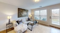 This well-designed one-bedroom, one-bathroom residence offers a thoughtful single-floor layout that balances comfort and functionality. The kitchen is outfitted with white shaker cabinetry, a classic subway tile backsplash, light quartz countertops, and a full suite of stainless steel appliances, including a refrigerator, electric range, and over-the-range microwave. A dual-basin sink and generous counter space make meal preparation efficient and convenient. The open living area is bright and welcoming, featuring warm wood-look flooring that extends throughout the unit. Large windows allow natural light to fill the space and provide views of the surrounding greenery, creating an airy and comfortable atmosphere. The bedroom is a serene retreat, complete with a spacious walk-in closet and a large window that further enhances the sense of openness. The full bathroom is cleanly finished with a white vanity, a framed mirror, and a tub and shower combination enclosed by glass sliding doors, all set on matching wood-look flooring. Neutral gray tones and white trim throughout the unit lend a cohesive, contemporary aesthetic. The secure front entry and functional layout make this residence a practical and inviting place to call home.