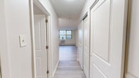 Located at 1320 W Somerville Ave in Philadelphia, PA, this efficiently laid-out unit offers a clean, modern aesthetic across a single floor. Light hardwood-style flooring runs seamlessly throughout the space, creating a cohesive and airy feel.

The open living area is bathed in natural light from a large multi-pane window fitted with blinds, and includes a wall-mounted air conditioning unit and baseboard heating, providing year-round comfort. The neutral white walls and light flooring contribute to a bright, open ambiance.

The kitchen is thoughtfully designed with white shaker-style cabinetry, a gas range, a full-size refrigerator, and a single-basin sink. A peninsula with a light countertop extends into the living space, providing additional prep space and a casual dining option. Track lighting illuminates the kitchen area effectively.

The bathroom features a clean, all-white design with a combination bathtub and shower, a white vanity with under-cabinet storage, a mirrored medicine cabinet, and wood-look tile flooring that complements the rest of the unit.

A hallway connects the main living areas and provides access to the unit's entrance, complete with a wood-panel door. The overall design prioritizes functionality and simplicity, making this a practical and well-appointed space in the Philadelphia neighborhood of Ogontz.
