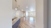 This single-story unit in Hurricane, Utah offers a practical and well-appointed layout, accommodating four bedrooms, two bathrooms, two kitchens, and a living room within a compact yet efficiently designed floor plan. Light-toned luxury vinyl plank flooring runs throughout the main living areas, complemented by plush carpeting in the bedrooms, creating a clear distinction between shared and private spaces.

Both kitchens feature granite-look countertops, medium-toned shaker-style cabinetry, stainless and black appliance packages including dishwashers, ranges, and microwaves, and pendant lighting accents. An arched architectural detail in one kitchen adds a subtle design flourish.

The open living area connects seamlessly to the kitchen via a peninsula with an undermount sink. A ceiling fan and a window offering views of the surrounding desert hills and mountains provide comfort and natural light.

The bedrooms are bright and neutrally finished, each with windows fitted with blinds. The primary bedroom includes a ceiling fan and light wood flooring, while secondary bedrooms feature soft carpeting. Both bathrooms include tub/shower combinations with tile surrounds, wood-look flooring, and granite-topped vanities.
