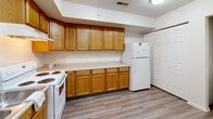 Located at 1324 Lafayette Ave in Kalamazoo, Michigan, this two-bedroom, one-bathroom residence offers a practical and comfortable single-floor layout. The open-concept living, dining, and kitchen area forms the heart of the home, creating a connected and functional shared space. The kitchen is outfitted with warm oak cabinetry offering generous upper and lower storage, light countertops, white appliances including a range, dishwasher, and refrigerator, and durable wood-look flooring that extends throughout.

A half-wall pass-through connects the kitchen to the living and dining area, which features neutral carpet and a textured ceiling. The two bedrooms are carpeted and finished in crisp white, with the primary bedroom offering a closet with wire shelving. Both bedrooms receive natural light through windows with views of surrounding greenery. Each bedroom also includes a dedicated closet for ample storage.

The bathroom features a warm wood-toned vanity with a white countertop, a large mirror with overhead lighting, a tub-shower combination, and wood-look flooring. An in-unit laundry area adds everyday convenience. The overall palette of white walls, neutral carpet, and warm wood tones gives the residence a clean, cohesive aesthetic throughout.