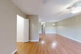 Located at 2801 NW 91st Ave in Coral Springs, Florida, this single-story, one-bedroom, one-bathroom home offers a thoughtfully arranged layout with a warm, neutral aesthetic throughout. The combined living and dining area serves as the heart of the home, featuring gleaming hardwood-style flooring, soft taupe walls, textured ceilings, and a ceiling fan that adds both comfort and style. A pendant light fixture anchors the dining space, while the open sightlines create a spacious, airy feel. The kitchen is well-equipped with ample white cabinetry trimmed in light wood, a double-basin sink, black appliances including an electric range and dishwasher, and hardwood-style flooring that flows seamlessly from the main living areas. The generously sized bedroom offers plush carpeting, a ceiling fan, and natural light from a window, creating a comfortable retreat. Three closets—including a walk-in with wire shelving—provide abundant storage. The bathroom features a wide vanity with a large mirror and hardwood-style flooring. A dedicated laundry room houses a full-size washer and dryer with overhead wire shelving. The home also includes a private patio, completing this well-appointed and functional living space.