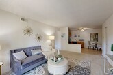 Located at 2022 Tavel Ct in Maryland Heights, Missouri, this single-story, one-bedroom, one-bathroom residence offers a practical and well-organized floor plan across a comfortable footprint. The open-concept living area is bright and welcoming, featuring neutral-toned carpeting, a textured ceiling, and a sliding glass door that fills the space with natural light while providing outdoor access. The layout flows seamlessly from the living area toward the kitchen, which is defined by warm wood cabinetry, light countertops, and a full suite of black appliances including a refrigerator, range, dishwasher, and microwave. A dining nook adjacent to the kitchen offers a cozy space for meals. The bedroom is generously proportioned, carpeted throughout, and benefits from a large window that brings in ample natural light, creating a calm and restful atmosphere. A dedicated closet provides practical storage. The bathroom features a wide vanity with a large mirror and wood cabinetry beneath, maintaining the clean and neutral aesthetic found throughout the home. A hallway connects the rooms efficiently. Overall, the residence presents a cohesive, light-filled interior with a functional layout well-suited for comfortable everyday living.