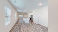 Located at 4236 Hollow Wind Way in Summerville, SC, this single-story home presents a clean, modern interior designed for comfortable everyday living. The open-concept layout connects the kitchen and living areas seamlessly, with wood-look luxury vinyl plank flooring extending throughout the main living spaces and recessed lighting illuminating the interiors.

The kitchen is a standout feature, equipped with white shaker-style cabinetry, granite countertops, and a full suite of stainless steel appliances including a refrigerator with ice maker, electric range, and built-in microwave. A central island with an integrated sink provides additional workspace and casual seating, while windows overlooking the living area allow natural light to flow freely throughout.

The bedrooms are carpeted for comfort, with windows admitting natural light and generous closet space, including a walk-in closet outfitted with wire shelving systems. The primary bathroom offers a double vanity with white cabinetry, a framed walk-in shower with glass doors, and wood-look flooring. A secondary bathroom features a single vanity with a mirror and classic fixtures. A dedicated laundry area with wire shelving and utility hookups rounds out this well-organized home.