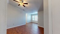 Located at 301 N Gross Rd in Kingsland, Georgia, this single-story, 3-bedroom, 2-bathroom home offers a well-organized and functional layout. The open-concept living, dining, and kitchen area serves as the heart of the home, characterized by rich hardwood-style flooring, vaulted ceilings, and ceiling fans that promote comfortable airflow. Natural light filters in through window blinds, brightening the neutral gray walls throughout.

The kitchen features warm honey-toned cabinetry, a stainless steel range, and a peninsula with a white countertop that opens seamlessly to the living and dining areas — ideal for everyday use and entertaining. The transition from the main living space into the hallways and bedrooms is clean and well-defined.

All three bedrooms are carpeted for comfort and each includes a ceiling fan and window. The primary bedroom offers a generous footprint with direct closet access. Four closets in total provide ample storage across the home.

Both bathrooms are finished with wood-style flooring, wood-toned vanity cabinetry, white countertops, and tub-shower combinations with tiled surrounds. A dedicated laundry room with washer/dryer hookups and overhead wire shelving, along with a separate utility room, rounds out the practical features of this well-appointed home.